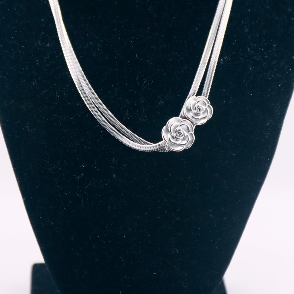 Collana modello a doppio filo con pendente rosa stilizzata